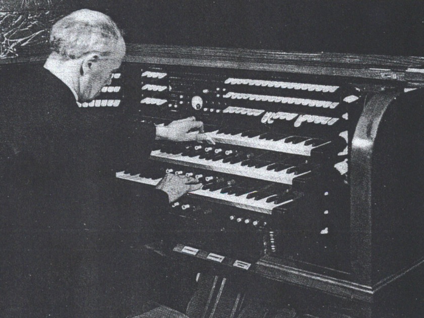 don Eugenio Bussa mentre suona l'organo rinnovato nel 1968